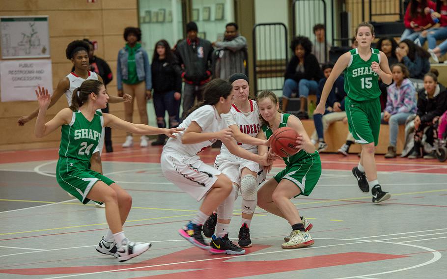 Players battle for the ball during a basketball game between SHAPE and Kaiserslautern at Kaiserslautern High School, Germany, Friday, Dec. 6, 2019. SHAPE won the game 45-40. 