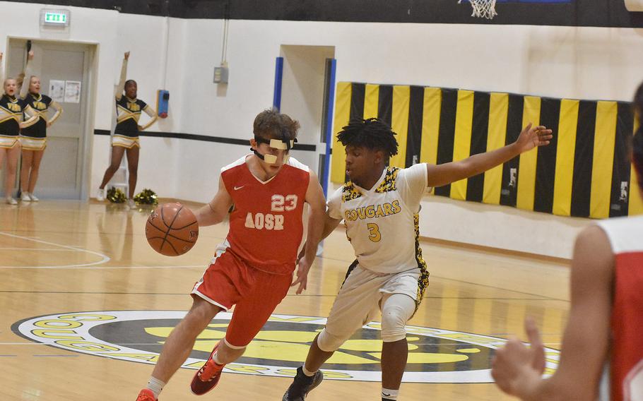 American Overseas School of Rome's Niv Eshel drives against Vicenza's Zach Cohen on Friday, Dec. 6, 2019. The Falcons topped the Cougars 61-48.