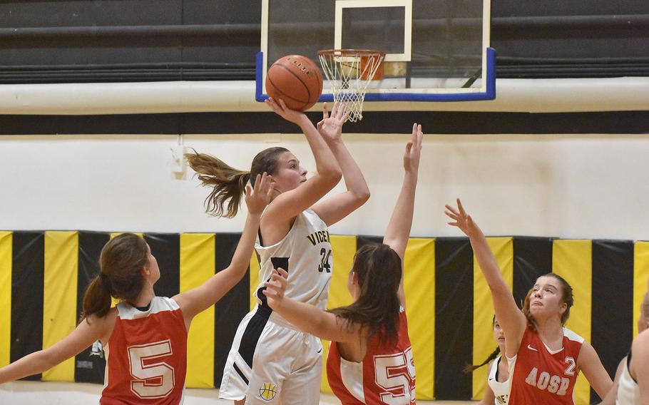 Vicenza's Claire Troiano puts up a shot while surrounded by Ameircan Overseas School of Rome defenders in the Cougars' 41-33 victory on Friday, Dec. 6, 2019.