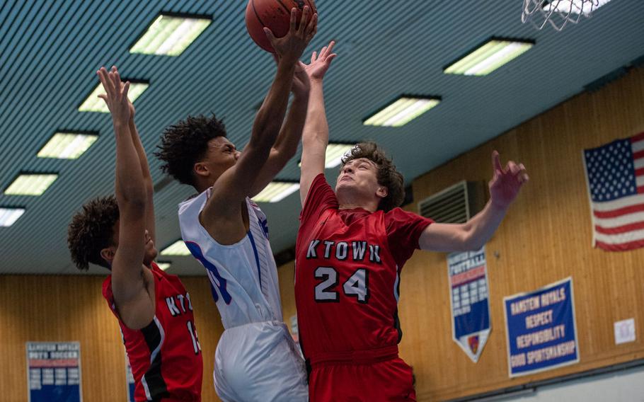 Ramstein's Jerod Little drives to the basket as Kaiserslautern's Isaak Pacheco goes up for the block during a basketball game at Ramstein High School, Germany, Dec. 17, 2019. Ramstein won the game 72-56. 

