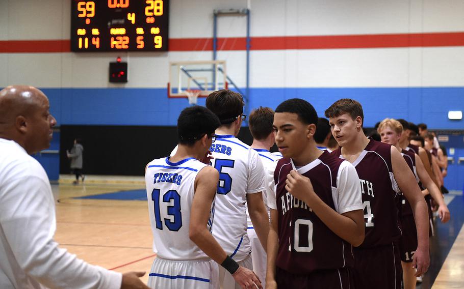 The Hohenfels Tigers and AFNORTH Lions' boys basketball teams shake hands at the conclusion of Friday's game, which was held at Hohenfels. The Tigers beat the Lions 59-28.  