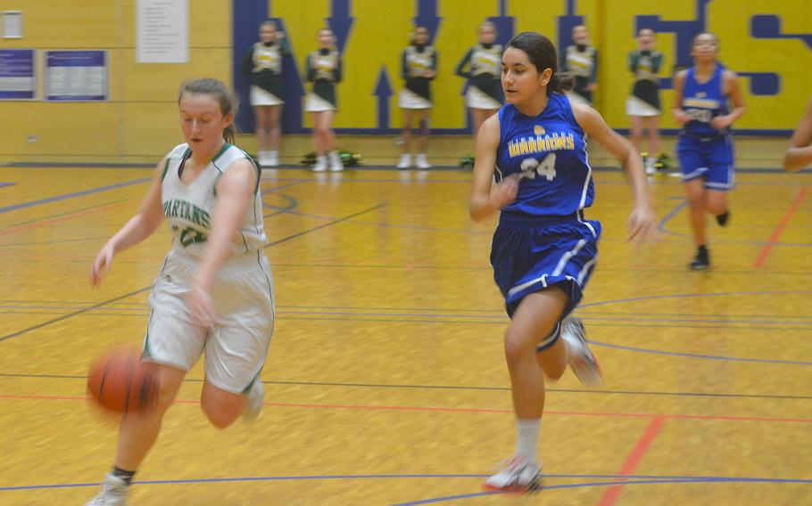SHAPE's Gabi Shultz drives the ball past Wiesbaden defenders. The Spartans beat the Warriors 40-26.