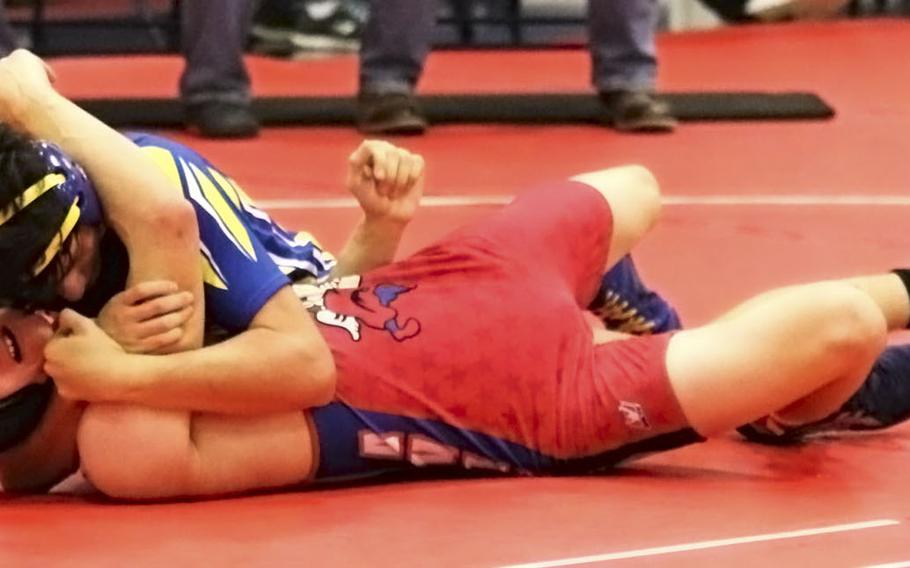 Noah Bachicha of the Sigonella Jaguars attempts to pin Chandler Clark of the Aviano Saints in the 138-pound weight class' third-place match during Saturday's wrestling tournament held at Aviano. Bachicha succeeded pinning Clark and won the match.