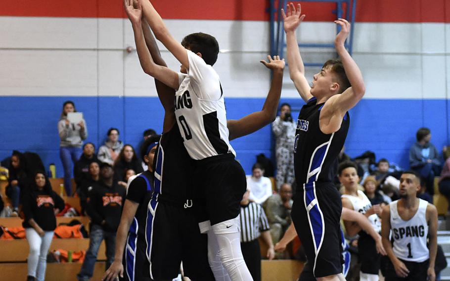 Spangdahlem Sentinel Alden Vasquez, left, blocks a shot during Saturday's boys varsity basketball game against the Hohenfels Tigers, held at Hohenfels. The Sentinels beat the Tigers 69-60.
