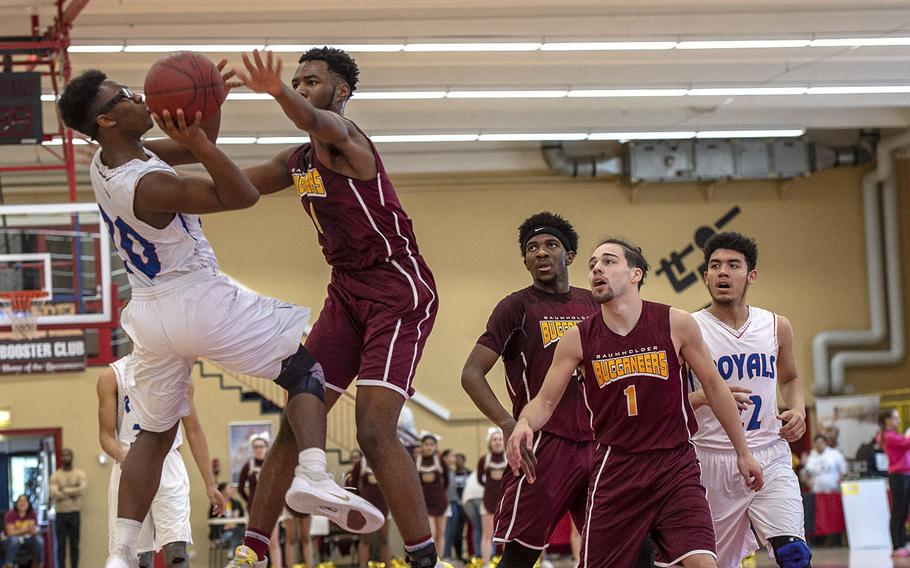 Ramstein's Elisha Williams tries to avoid a block while shooting during Saturday's boys varsity basketball game against Baunholder, held at Baumholder. Ramstein won the game 52-44.