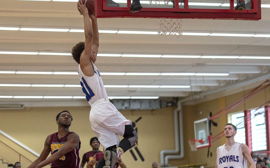 Ramstein's Jason Jones goes up for a dunk during Saturday's boys varsity basketball game against Baunholder, held at Baumholder. Ramstein won the game 52-44.