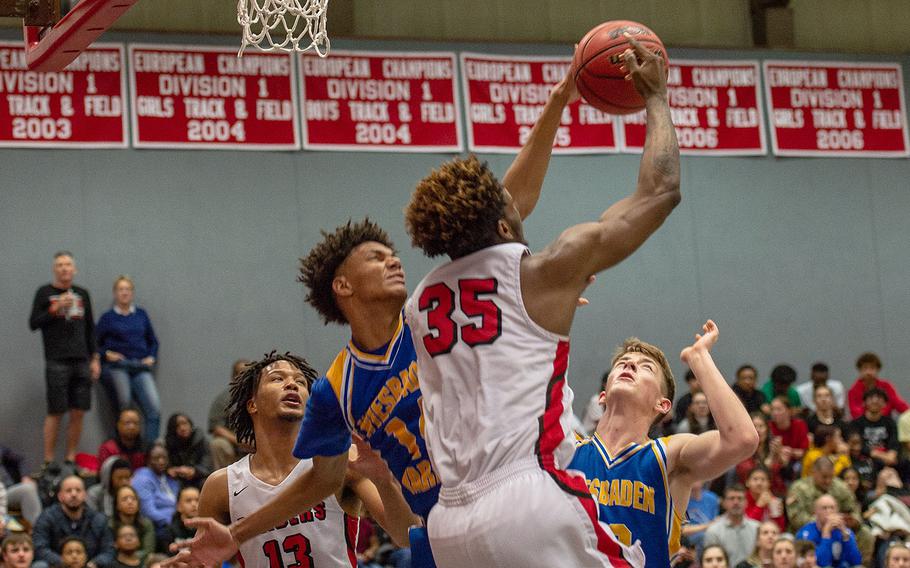 Wiesbaden's Dom Bivins blocks a shot from Kaiserslautern's Tre Dotson  during a basketball game in Kaiserslautern, Germany, Friday, Jan. 31, 2020. Wiesbaden won the game 76-75.  