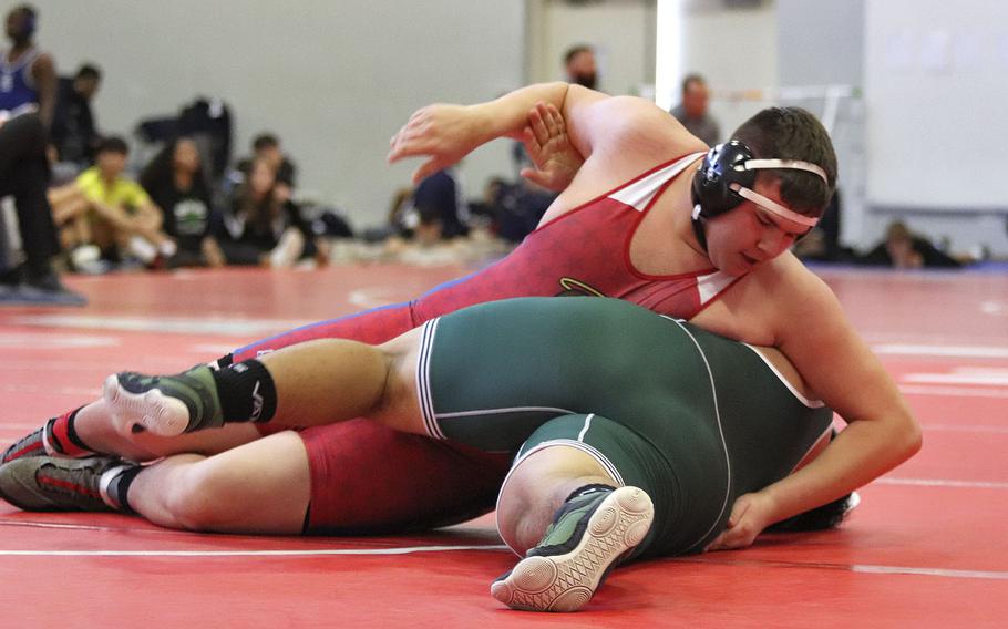 Jonathen Stagner of the Aviano Saints attempts to better his position against Xzayver Salas of the Naples Wildcats in the 285-pound weight class of Saturday's wrestling sectional held at Aviano, Italy. Stagner won with a score of 4-1.