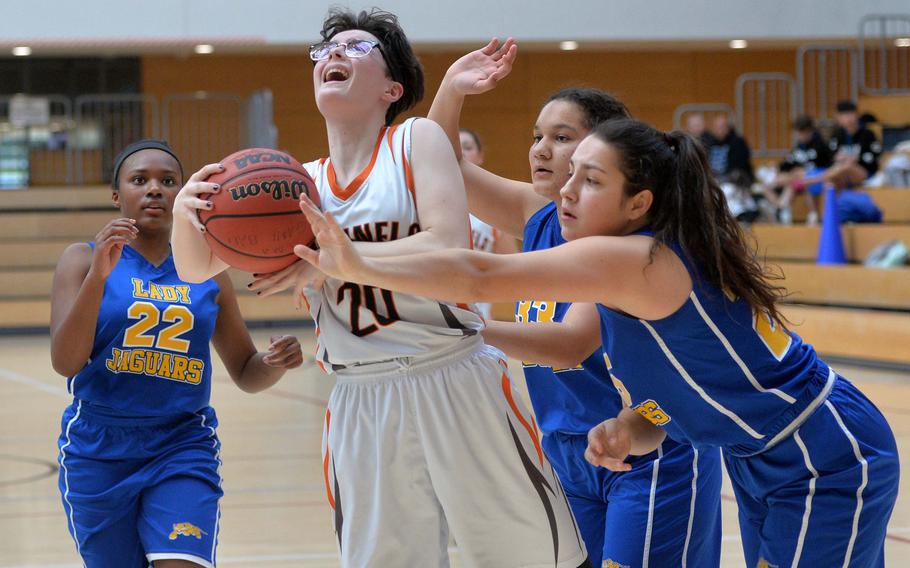 Lorelai Vargo of Spangdahlem is stopped by Katie Payne of Sigonella with a foul as Shanyah Kentish, left, and Jocelyn Harris watch. The Sentinels advanced to the Division III finals with a 39-14 win at the DODEA-Europe basketball championships in Wiesbaden, Germany, Friday, Feb. 21, 2020. 