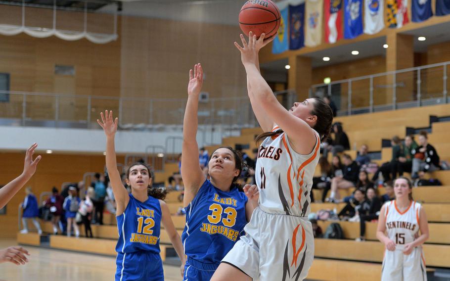 Izzy Smith of Spangdahlem shoots as Sigonella's Jocelyn Harris defends. The Sentinels advanced to the Division III finals with a 39-14 win at the DODEA-Europe basketball championships in Wiesbaden, Germany, Friday, Feb. 21, 2020. 