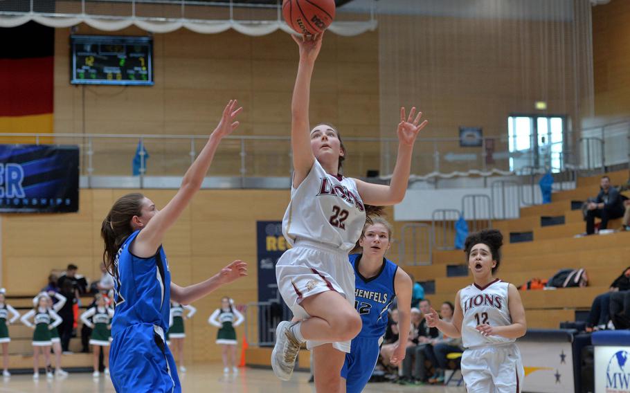 Paula Bohlen of AFNORTH goes in for a basket against Allison Wenger of Hohenfels as Tiana Rodgers and Lachelle Ellis, right, follow the action in a Division III semifinal at the DODEA-Europe basketball championships in Wiesbaden, Germany, Friday, Feb. 21, 2020. The Tigers beat the Lions 36-31 to advance to the finals.