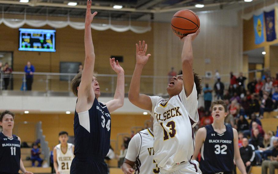 Mathew Gardner scores one of Vilseck's overtime baskets as Brandon Lee of Black Forest Academy tries to defend. The 53-49 overtime win sends Vilseck to the Division I final of the DODEA-Europe basketball championships.