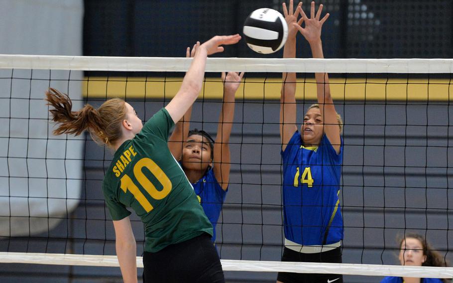 Clara Oberle of SHAPE hits past the Wiesbaden defense of Calen Prevo, left, and Alynna Palacios in a Division I match at last year's DODEA-Europe volleyball championships in Ramstein, Germany. The upcoming high school volleyball season in Europe has been canceled.








