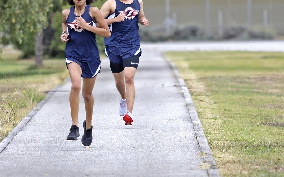 Savannah Dismute and Brandon Hwang sprint to the finish during Saturday's cross country meet at Aviano. Dismute placed second in the girls race with a time of 23 minutes, 27 seconds. Hwang finished with a time of 23:58.