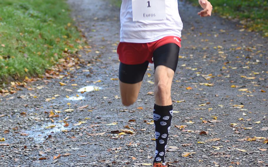 Kaiserslautern senior Griffen Parsells raises his hand as he crosses the finish line in first at the DODEA-Europe non-virtual cross country championship on Saturday, Oct. 24, 2020, at Seewoog Park in Ramstein-Miesenbach, Germany. Parsells, the defending European champion, was the top runner in the large schools race and had the top time overall.