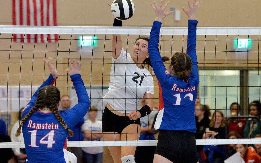 Stuttgart's Karen Kosinski slams the ball past the Ramstein defense of Lauren Szczygeil, left, and Sequoia Juhaz in the Division I final at the DODEA-Europe volleyball championships in Kaiserslautern, Nov. 2, 2019. The two teams won't square off until at least January this season as coronavirus concerns have pushed back the start of play.