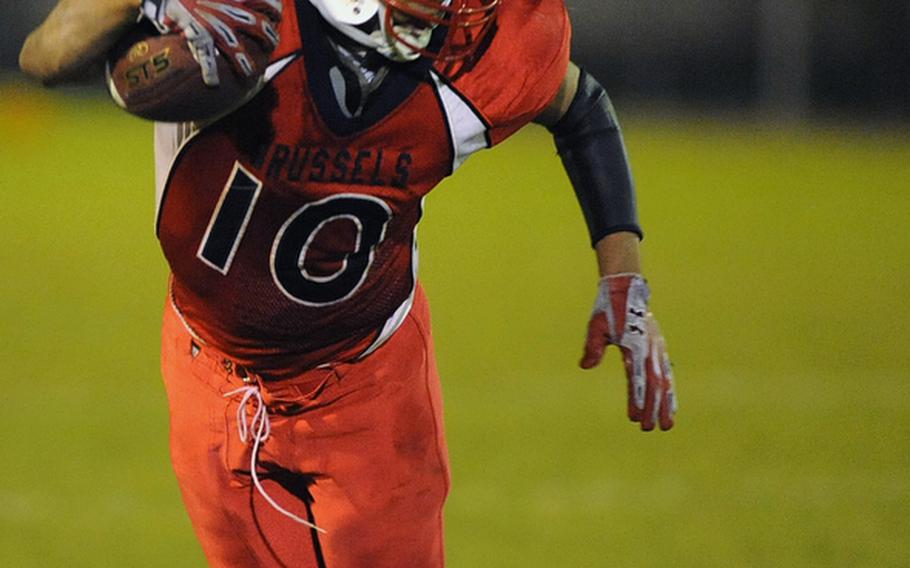 Stephen Clark of ISB, left, tries to escape a flying tackle by Mannheim's LaJuarren Burks during Friday night's game at Mannheim. The Bison won their final regular season home football game 21-14.