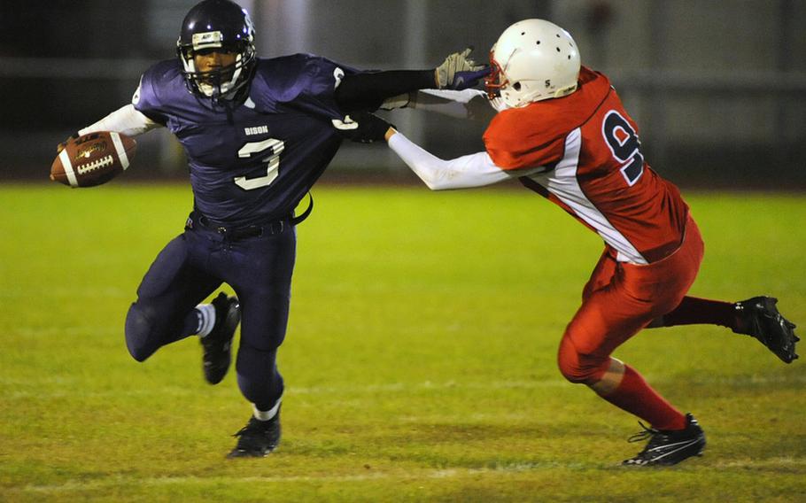 Mannheim's Aaron Garrison, left, rushes upfield despite the defense of International School of Brussels' Tim Overeem. Mannheim beat ISB 21-14 in their final regular season home game.