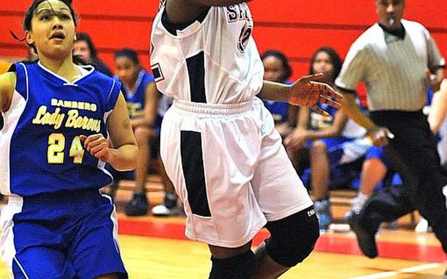 Aviano's Kyerha Smith goes to the basket after getting past Bamberg's Loleen Tomokane in their Division II game at the DODDS Europe basketball finals on Wednesday. The top-seeded Lady Saints defeated Bamberg, 39-20.