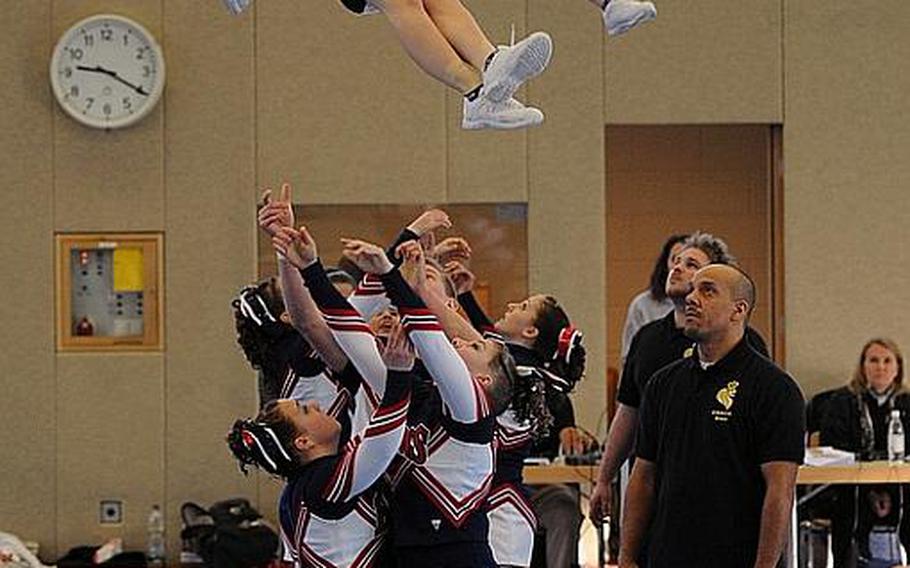 A pair of Bitburg Barons cheerleaders sail through the air during their routine at the DODDS Europe Cheer Championships in Mannheim, Germany.