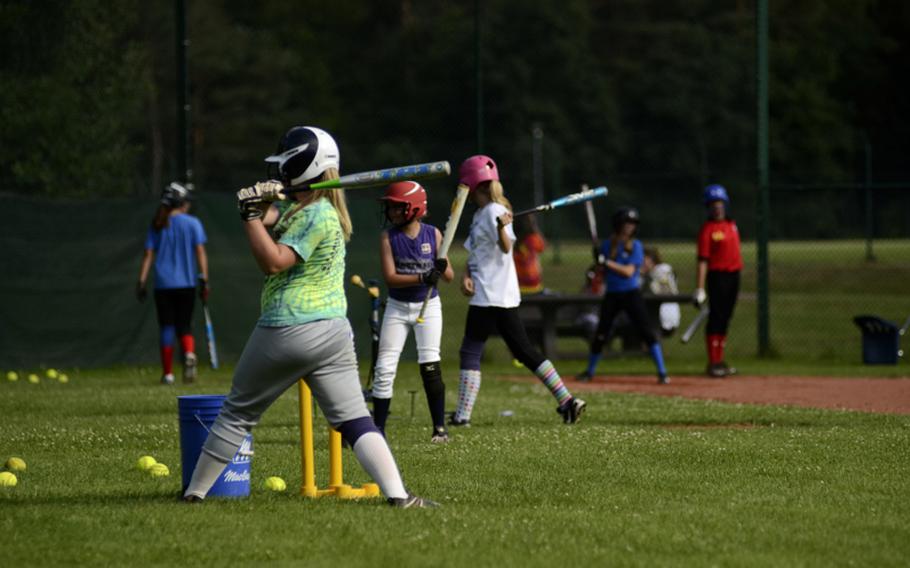 From near to far, Emily Hickam, third baseman-second baseman-pitcher; Alaina Goar, right fielder-pitcher; and Sierra Nelson, third baseman-left fielder, make use of batting tees during practice July 6, 2012, at Ramstein Air Base. The 11-12 year-old All-Stars were preparing to represent Germany at the upcoming European Little League Regionals at Caronno Pertusella, Italy.