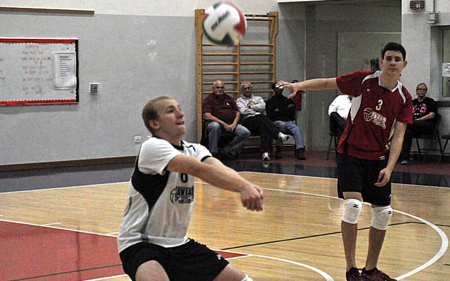Aviano libero Jeremy Owens starts the Saints offense while Spencer Ridgway watches. The Saints fell to the American Overseas School of Rome on Friday, 23-25, 25-22, 29-27, 25-21.