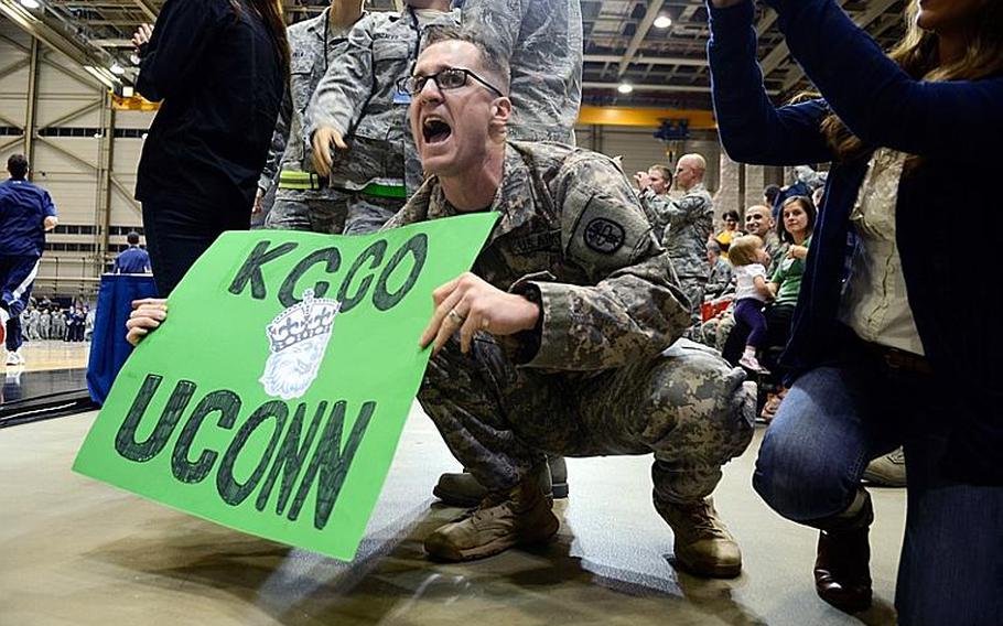 U.S. Army Spc. Philip Gray, a medical technician at Landstuhl Regional Medical Center, cheers for his team Nov. 9, 2012, as they run onto the court for the Armed Forces Classic at Ramstein Air Base, Germany. Connecticut upset No. 14 Michigan State 66-62.