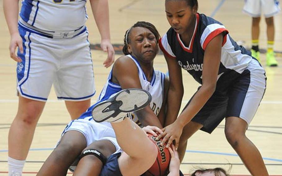 Bitburg's Brandy Oliver, center, and D'Myla Thornton fight Ansbach's Jahka Smith for the ball as Alyssa Solis watches in the Division II title game at the DODDS-Europe Basketball Championships in Wiesbaden, Germany, Saturday. Bitburg took the title with a 49-39 win.