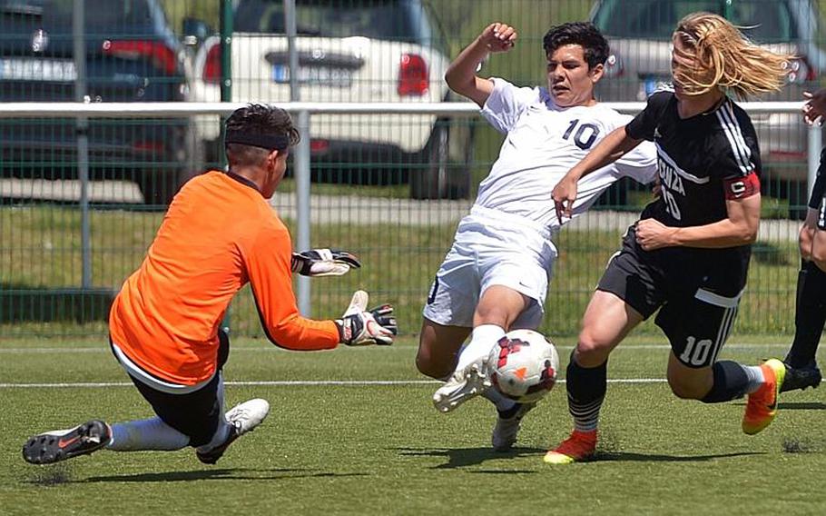 Vicenza keeper Alin Torres come out to stop Lakenheath's Tristin Reyes, with the help of teammate Nicholas Galles  in Division I action at the DODEA-Europe soccer championships in Reichenbach, Germany. Lakenheath won 2-0.