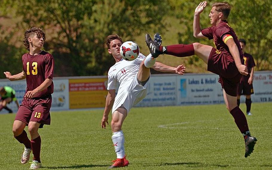 Kaiserslautern's James Austin and Vilseck's Nathaniel McClintock battle for a ball as Alex Rodriguez watches the action at left. Kaiserslautern beat Vilseck 7-0 in Division I action at the DODEA-Europe soccer championships in Reichenbach, Germany.