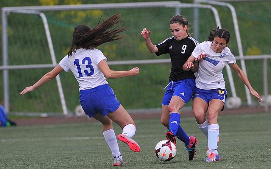 Hohenfels' Millian Comas-Ramos fights for the ball with Sigonella's Korley Jones as teammate Krystiana Wyrick comes in to help. Sigonella beat Hohenfels 3-1 in a Division III game at the DODEA-Europe soccer championships in Landstuhl, Germany.