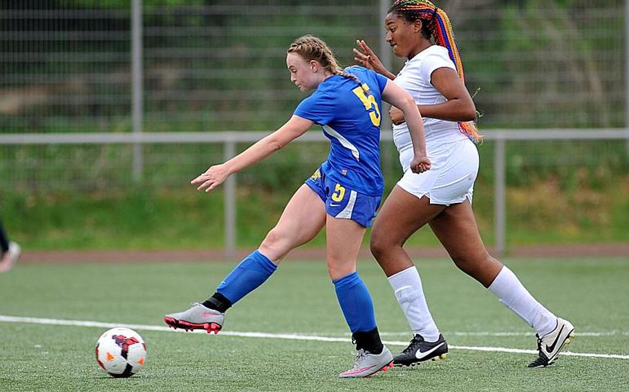 Sigonella's Violender Doke gets past Baumholder's Sierra Green to score a goal in the Jaguars' 4-0 win in a Division III game at the DODEA-Europe soccer championships in Landstuhl, Germany.