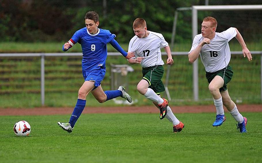 Brussels' Aljaz Urbanc gets away from Alconbury's Michael Price and Monroe Potter in a Division III game at the DODEA-Europe soccer championships in Landstuhl, Germany. Brussels won the game 3-1.