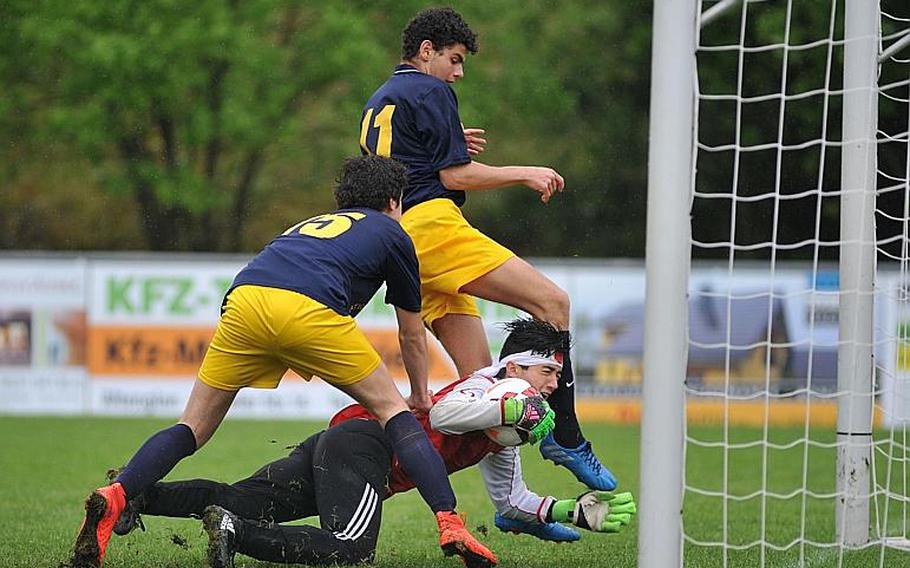 AOSR keeper Ariel Rand holds on to the ball despite the pressure by Florence's Giovanni Morescalchi and Francesco Ferragamo in a Division II semifinal at the DODEA-Europe soccer championships in Reichenbach, Germany. AOSR beat Florence 6-4 to advance to Saturday's final against Marymount.