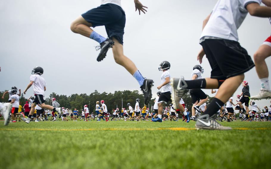 Players warm up during the annual European Football Camp at Vogelweh, Germany, on Tuesday, Aug. 15, 2017. Kaiserslautern High School hosted the four-day camp.