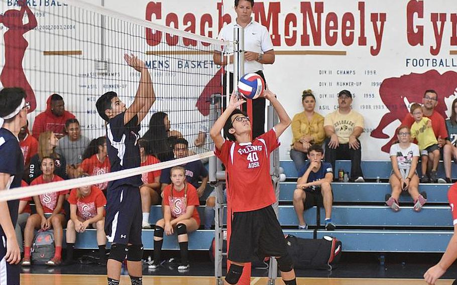 American Overseas School of Rome's Eduardo Lin sets the ball to his teammates Saturday while Aviano's Adrian Vasquez waits on the other side of the net in ta match in Aviano, Italy, Sept. 14, 2019. Boys volleyball will be played north of the Alps this coming DODEA-Europe winter sports season, replacing basketball due to coronavirus concerns.