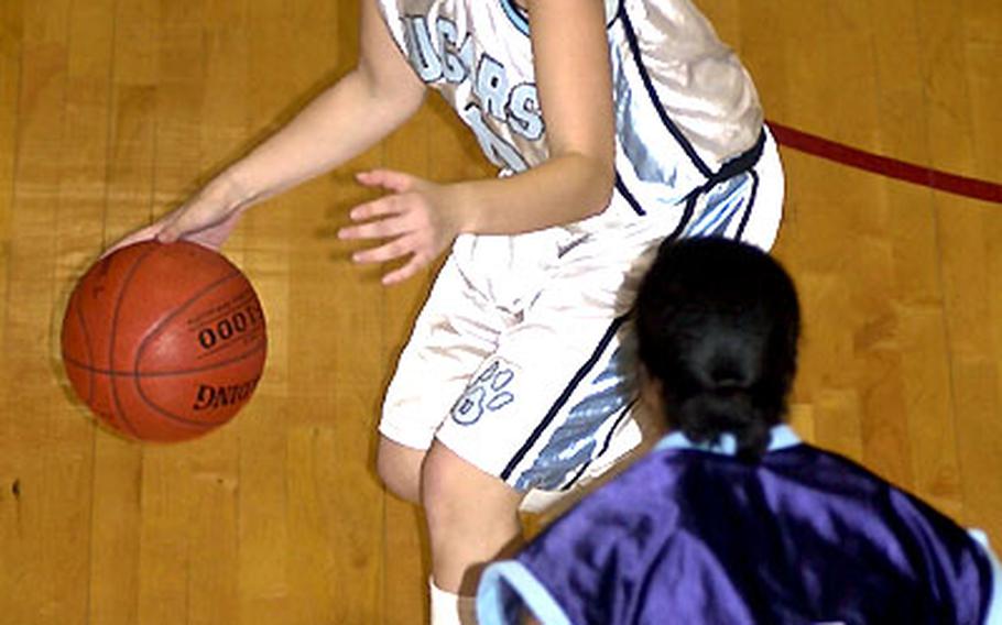 Osan American sophomore guard Sharon Kroening is defended by Katrina Lawrence of the Yongsan Runnin&#39; Rebels during Tuesday&#39;s action. Yongsan won, 55-29.