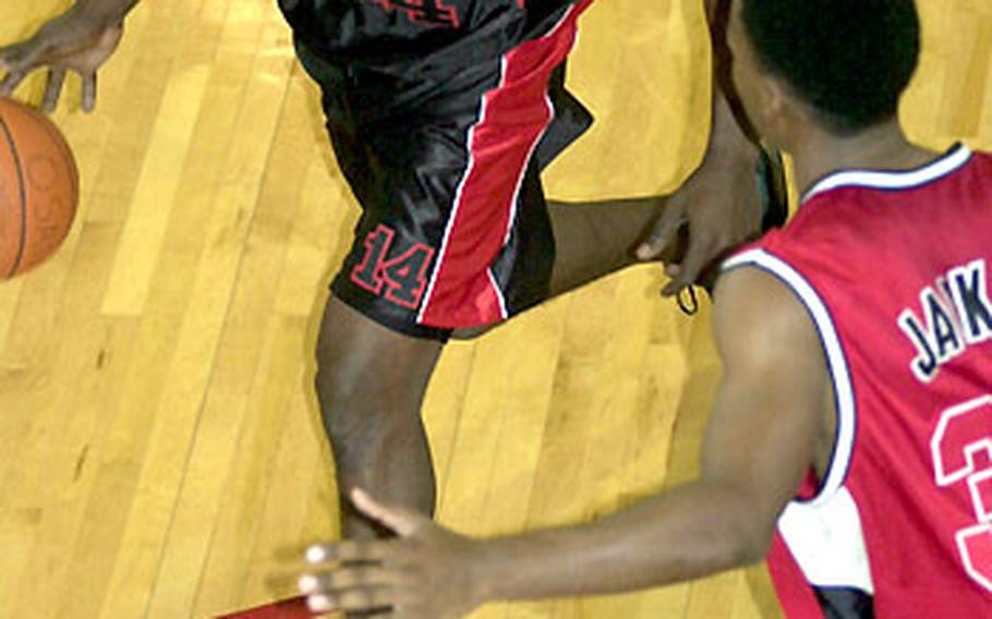 Marlowe Grimsley of Guam's Andersen Bombers looks to dribble past Jamaal Jackson of Camp Humphreys during Tuesday's round-robin play. Humphreys beat Andersen 106-100 in overtime.