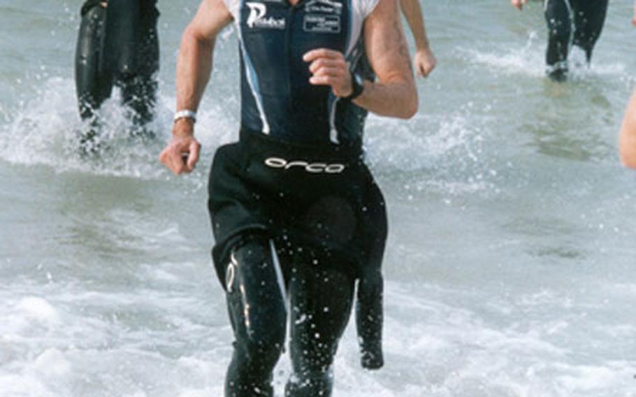 Leigh Plowman, comes running out of the water after the first leg of the Panama City Ironman competition in Florida. Plowman said he battled stomach cramps during the 2.6-mile swim.
