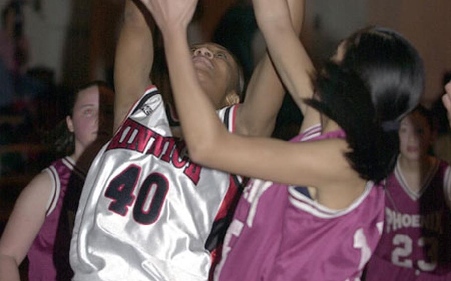 Tyesha Randall (40) of the Nile C. Kinnick Red Devils battles Yuri Koshibe of the Seisen International Phoenix for a rebound during Thursday&#39;s game. Kinnick won 50-29.