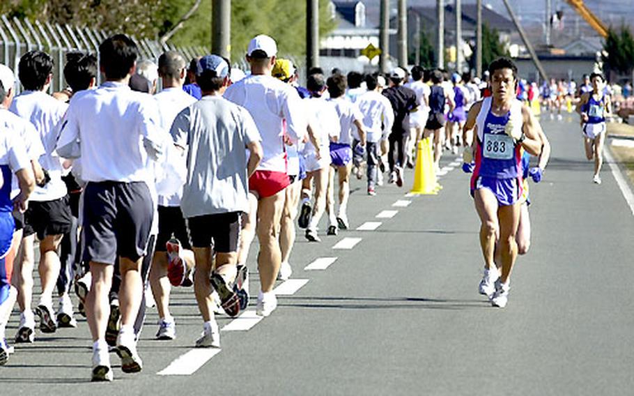 Eiji Yaguchi takes the lead going in one direction, while a pack of runners heads the other way during Sunday&#39;s race. Yaguchi placed third overall among the 2,883 men entered in the event.