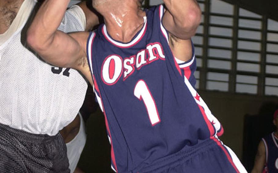 Guard Mark Esquier (1) of the Osan Defenders goes up to the basket against Orvin Wooten of Dynasty of Okinawa during Saturday's round-robin play in the 12th Martin Luther King Invitational Basketball Tournament at the Foster Field House, Camp Foster, Okinawa. Osan beat Dynasty 59-45.