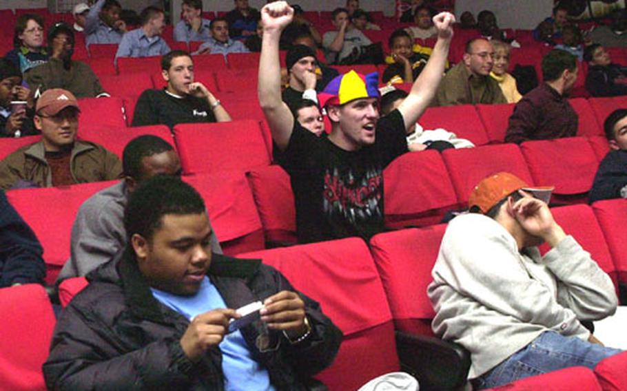 Football fans at Sasebo Naval Base cheer their teams during the Super Bowl on Monday morning. The game was shown on the movie screen at the base&#39;s Showboat Theater.