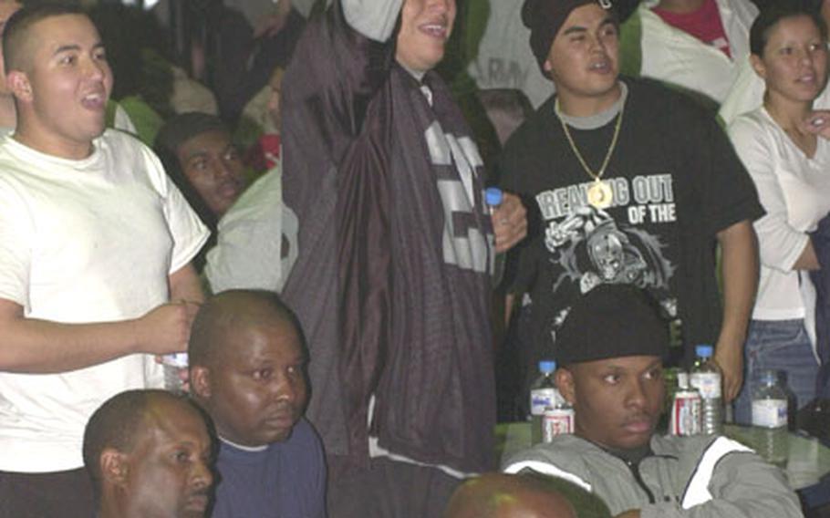 Raiders fans at Camp Doha, Kuwait, cheer on their team during Super Bowl XXXVII early Monday morning.