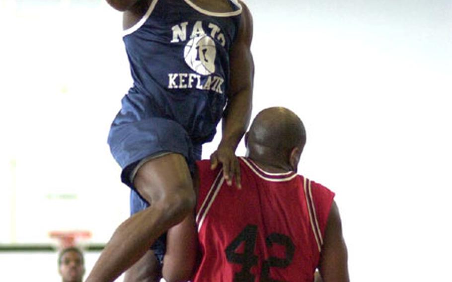 Keflavik&#39;s Otto Montgomery, left, sails over Alconbury&#39;s Dyrell Reeves during the final game of the USAFE Small Units Basketball Championships in Kaiserslautern, Germany, on Sunday. Keflavik won the game 90-84 to win the title.