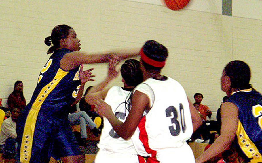 Heidelberg's Rhonda Williams, 32, swats a rebound away from Mannheim's Tanya Tyson and Cathy Holmes, 30, as Heidelberg teammate Katina Miles (right) look on.