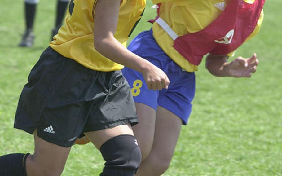 Dianne Abel, left, of the Kadena Panthers tries to boot the ball as Marcelle Ortiz of the Guam High Panthers defends during Thursday&#39;s semifinal of the Far East High School Girls Class AA (large schools) Soccer tournament at Trojans Field, Camp Zama, Japan. Guam High won 2-0 to reach Friday&#39;s final against Kubasaki of Okinawa.