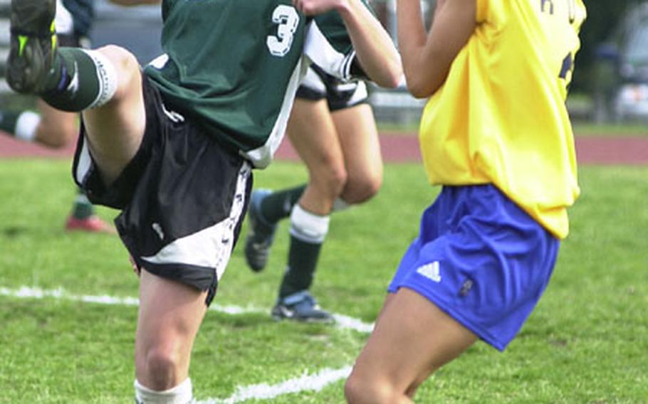 Sophomore striker Erin Foote, left, of the Kubasaki Dragons boots the ball high over Jessica Ruiz of the Guam High Panthers during Friday&#39;s final of the Far East High School Girls Class AA (large schools) Soccer Tournament at Trojans Field, Camp Zama, Japan. Foote scored both goals as Kubasaki won its second straight championship, beating the Panthers 2-0.