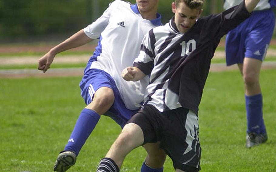 Hohenfels&#39; Richard Helsham, left, and Baumholder&#39;s Charles Otterstedt lunge for the ball during a DODDS high school soccer game in Baumholder, Germany, on Saturday.