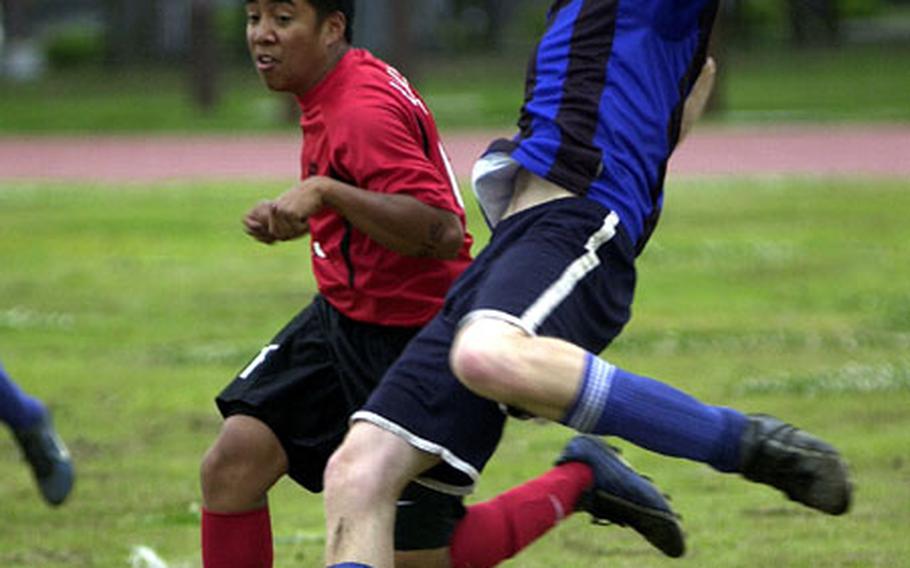 Luke Cummings, right, of the Christian Academy In Japan Knights readies to boot the ball as Ace Ranada of the Nile C. Kinnick Red Devils defends during Friday&#39;s quarterfinal of the Department of Defense Dependents Schools-Japan boys soccer tournament at Bonk Field, Yokota Air Base, Japan.